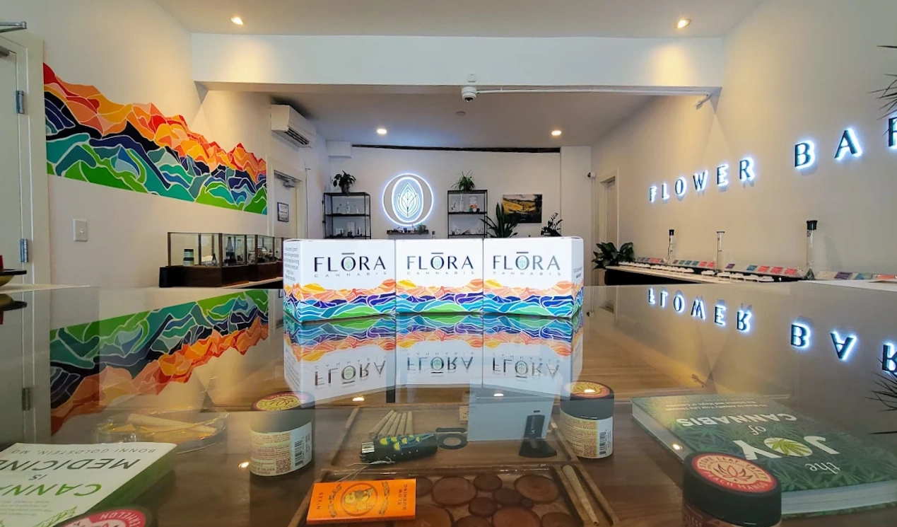 Branded boxes of flora cannabis sitting on a glass counter